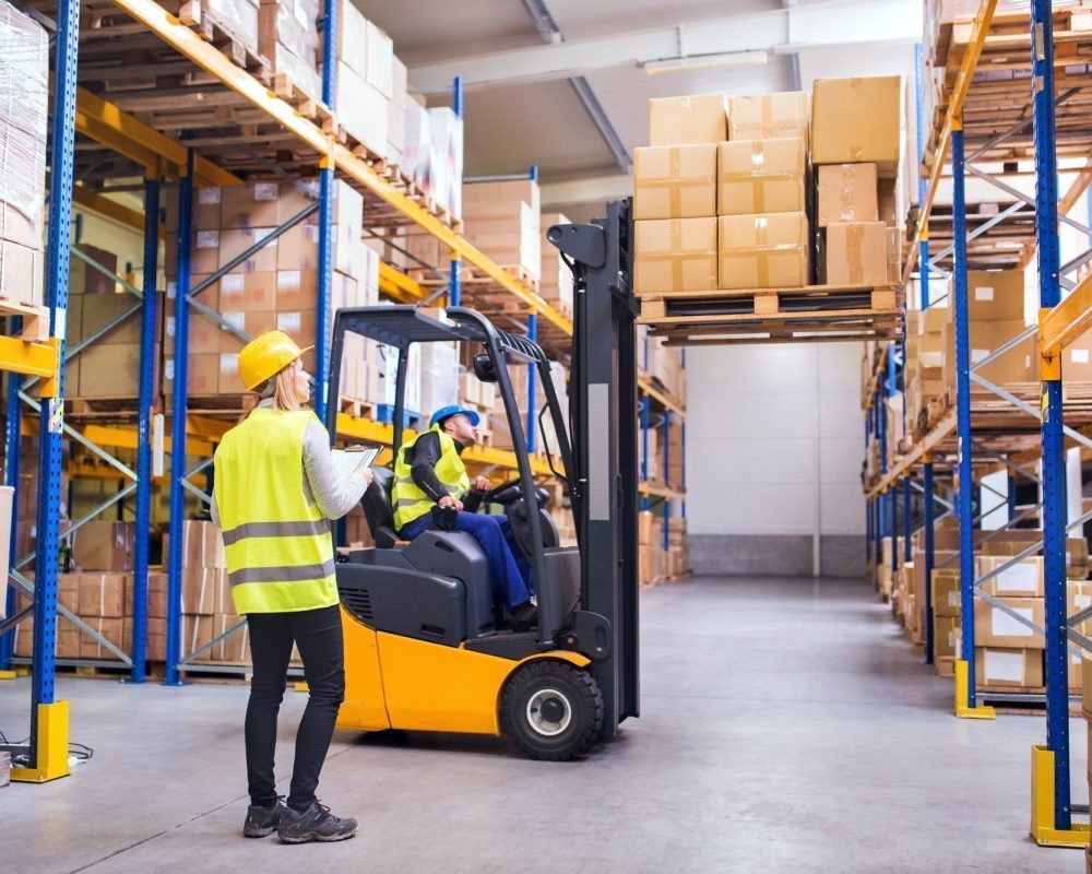 Young warehouse workers working together.